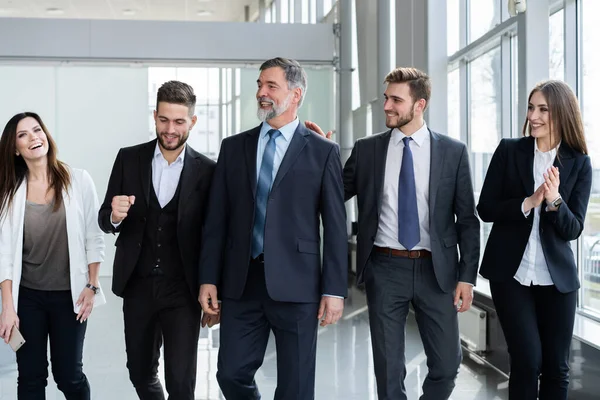 Affärsmän Team Walking I moderna kontoret, självsäkra affärsmän och affärskvinnor med Gammal ledare i förgrunden. — Stockfoto