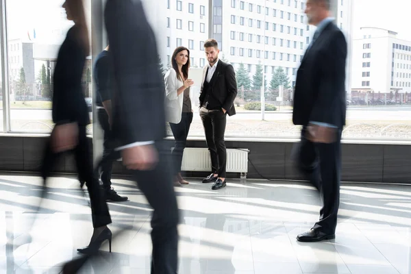 Werknemers op kantoor die overdag door de gang lopen. — Stockfoto