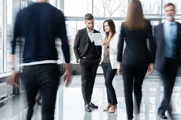 Lavoratori colletti bianchi che scendono corridoio ufficio durante la giornata lavorativa. — Foto Stock