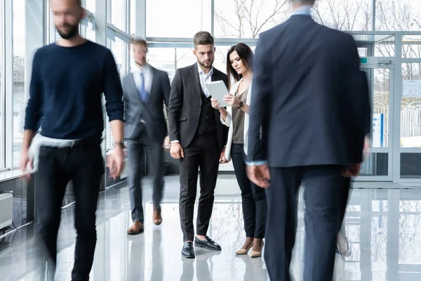 Lavoratori colletti bianchi che scendono corridoio ufficio durante la giornata lavorativa. — Foto Stock