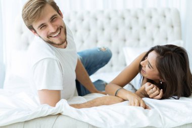 Genç mutlu çift yatakta birlikte yatıyor..