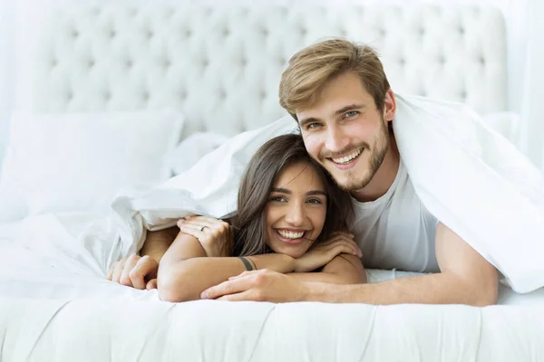 Young happy couple lying together in bed. — Stock Photo, Image