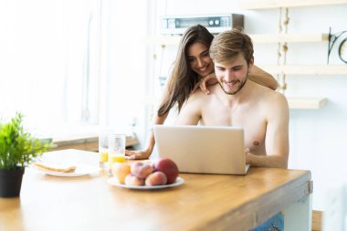 Mutfaktaki dizüstü bilgisayarda bir çift..