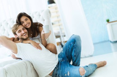 Sevgi dolu genç bir çift evdeki kanepede sarılıp dinleniyorlar..