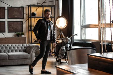 Mükemmel bir adam. Deri ceketli genç hippi odada dikiliyor..