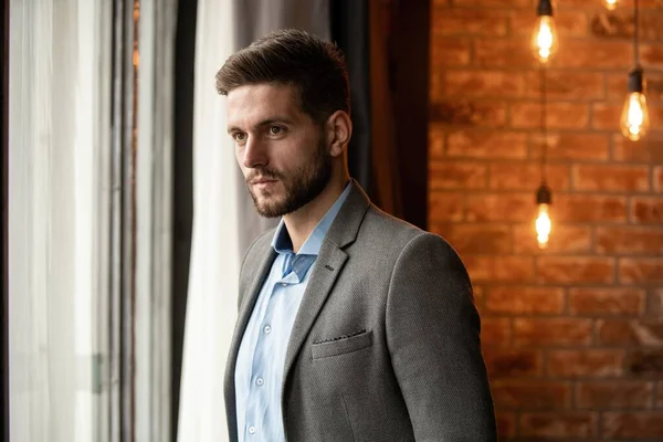 Thinking businessman in the office looking through the window. — Stock Photo, Image