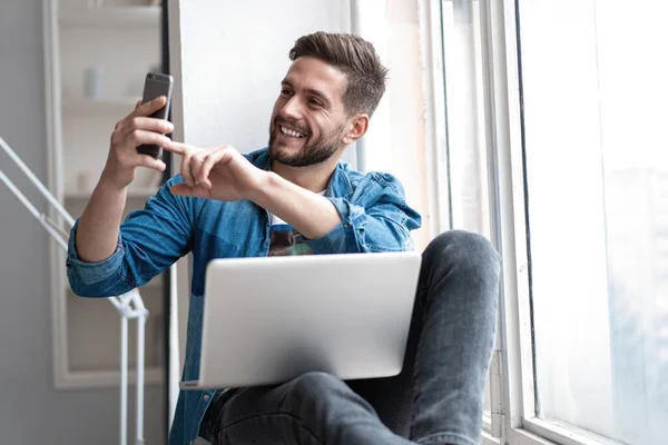 Jong gelukkig man praten video bellen via smartphone thuis. — Stockfoto