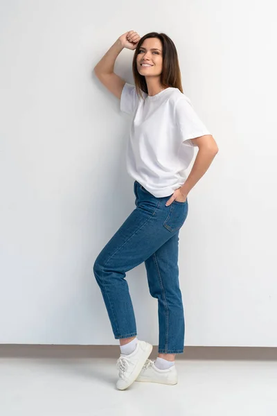 Retrato completo de uma bela jovem mulher feliz em pé sobre fundo branco . — Fotografia de Stock