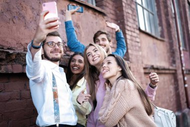 Yaz, tatiller, tatil ve mutluluk konsepti. Bir grup arkadaş akıllı telefondan selfie çekiyor.