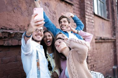 Yaz, tatiller, tatil ve mutluluk konsepti. Bir grup arkadaş akıllı telefondan selfie çekiyor.
