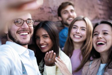 Yaz, tatiller, tatil ve mutluluk konsepti. Bir grup arkadaş akıllı telefondan selfie çekiyor.
