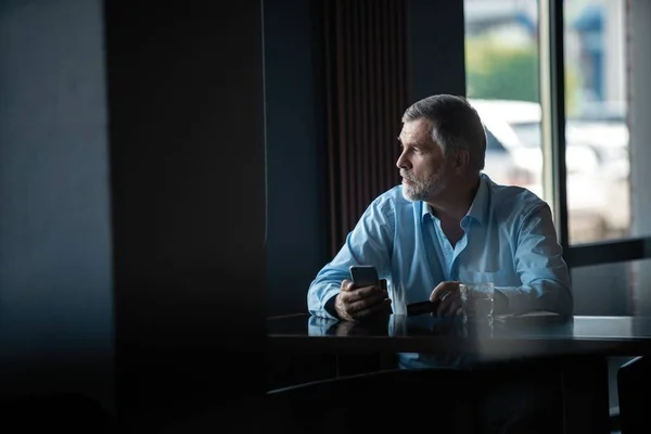 Hombre de negocios pensativo bebiendo café en la cafetería y mirando hacia otro lado . —  Fotos de Stock