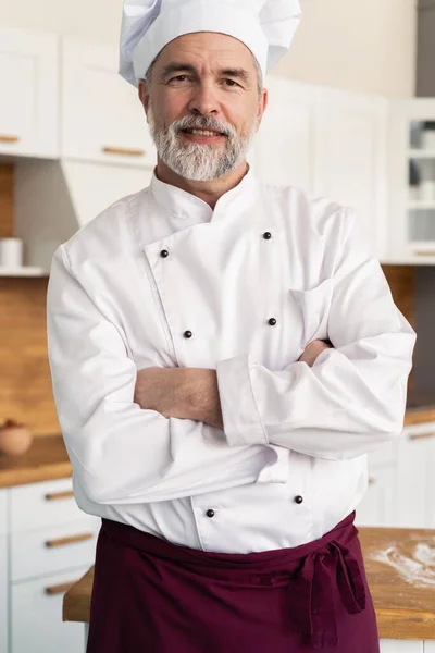 Atractivo chef caucásico de pie con los brazos cruzados en una cocina de restaurante — Foto de Stock