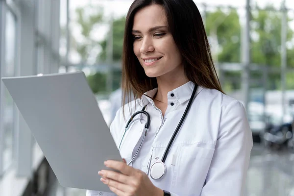 Woman doctor standing with folder at hospital. — Stock Photo, Image