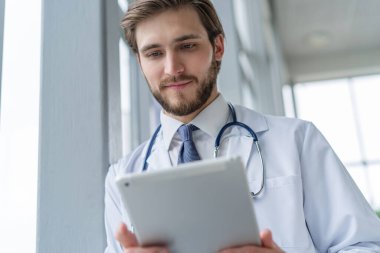 Erkek doktor hastanede tablet bilgisayar kullanıyor..