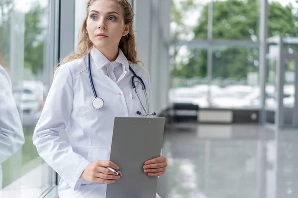 Woman doctor standing with folder at hospital. — Stock Photo, Image