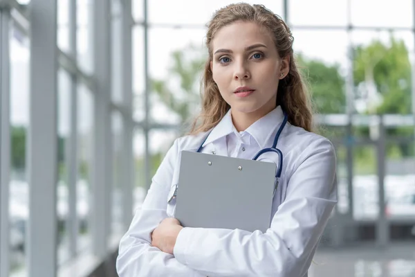 Mulher médico de pé com pasta no hospital. — Fotografia de Stock