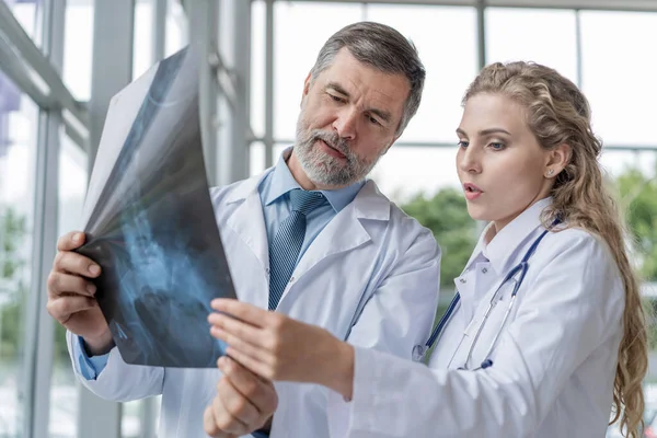 Orvosok röntgent analizálnak egy metingben. — Stock Fotó