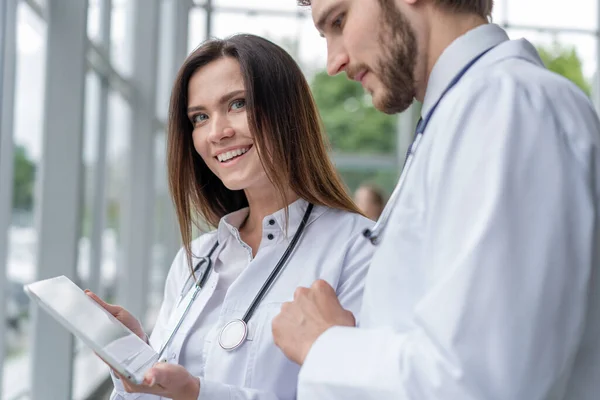 Médico masculino usando tablet digital com colega do sexo feminino no hospital, trabalhando juntos . — Fotografia de Stock