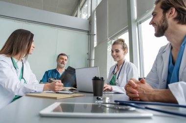 Tıbbi ekip hastalarla tedavi seçeneklerini tartışıyor. Bir grup doktor toplantı odasında toplantı yapıyor..