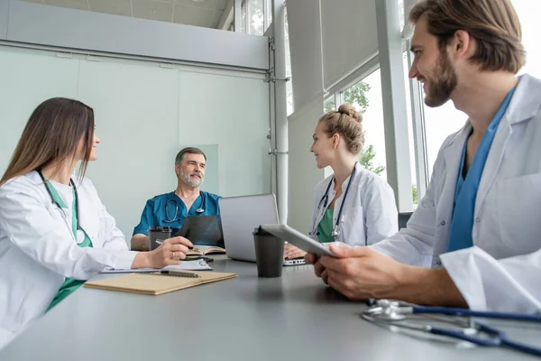 Equipo médico discutiendo opciones de tratamiento con los pacientes. Equipo de médicos teniendo una reunión en la sala de reuniones . — Foto de Stock