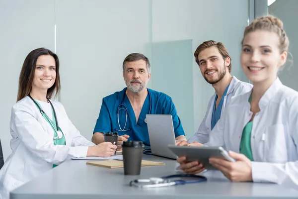 Equipo médico discutiendo opciones de tratamiento con los pacientes. Equipo de médicos teniendo una reunión en la sala de reuniones . — Foto de Stock