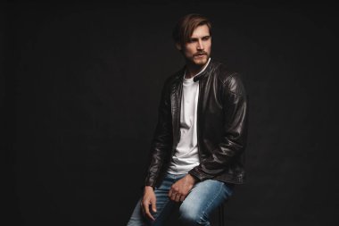 Moda adamı, yakışıklı, ciddi, güzel erkek model portresi deri ceket, siyah arka planda genç bir adam..