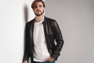 Moda adamı, yakışıklı, ciddi, güzel erkek model portresi deri ceket, beyaz arka planda genç bir adam..
