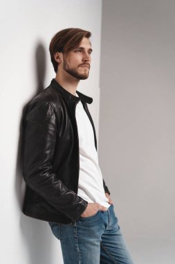 Moda adamı, yakışıklı, ciddi, güzel erkek model portresi deri ceket, beyaz arka planda genç bir adam..