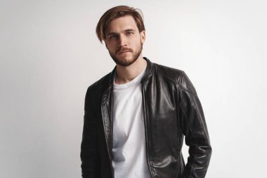 Moda adamı, yakışıklı, ciddi, güzel erkek model portresi deri ceket, beyaz arka planda genç bir adam..