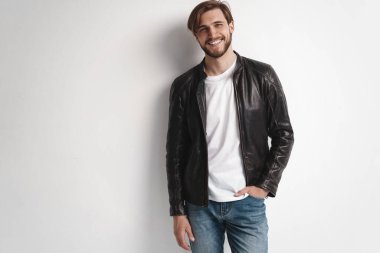 Moda adamı, yakışıklı, ciddi, güzel erkek model portresi deri ceket, beyaz arka planda genç bir adam..