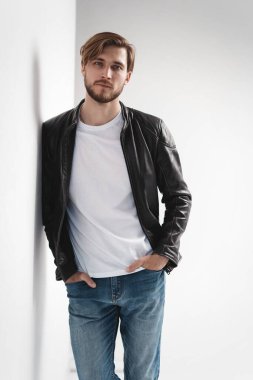 Moda adamı, yakışıklı, ciddi, güzel erkek model portresi deri ceket, beyaz arka planda genç bir adam..