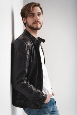 Moda adamı, yakışıklı, ciddi, güzel erkek model portresi deri ceket, beyaz arka planda genç bir adam..