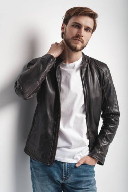 Moda adamı, yakışıklı, ciddi, güzel erkek model portresi deri ceket, beyaz arka planda genç bir adam..