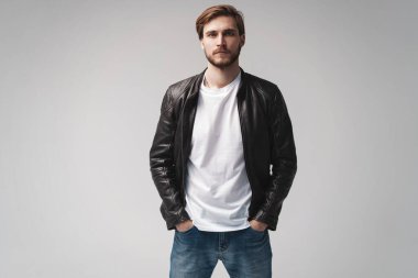 Moda adamı, yakışıklı, ciddi, güzel erkek model portresi deri ceket, beyaz arka planda genç bir adam..
