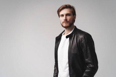 Moda adamı, yakışıklı, ciddi, güzel erkek model portresi deri ceket, beyaz arka planda genç bir adam..