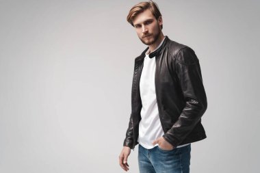 Moda adamı, yakışıklı, ciddi, güzel erkek model portresi deri ceket, beyaz arka planda genç bir adam..