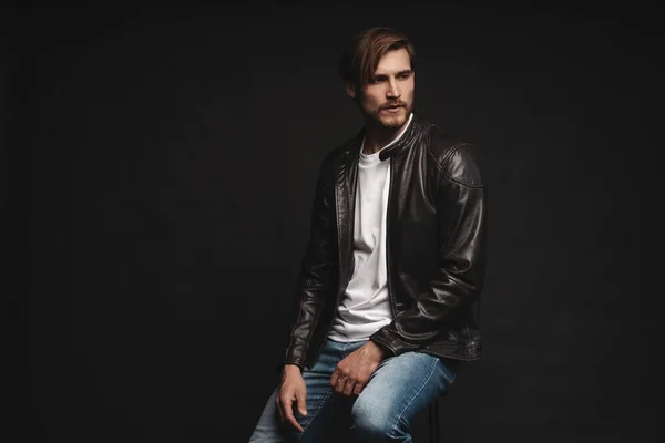 Fashion man, Handsome serious beauty male model portrait wear leather jacket, young guy over black background. — Stock Photo, Image