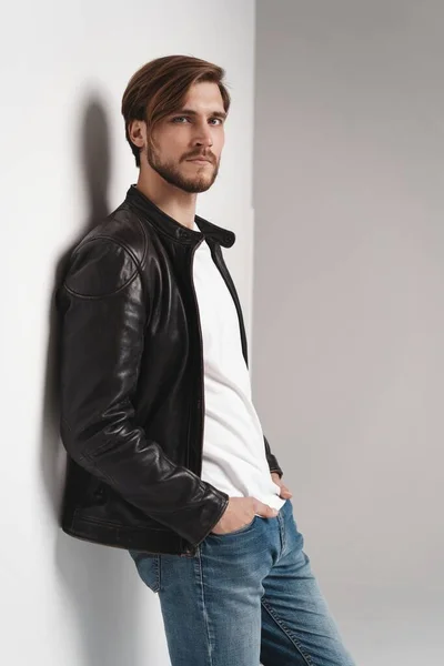 Moda adamı, yakışıklı, ciddi, güzel erkek model portresi deri ceket, beyaz arka planda genç bir adam.. — Stok fotoğraf