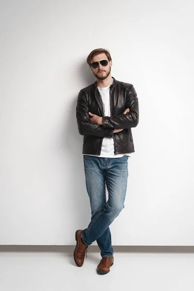 Fashion man, Handsome beauty male model portrait wear sunglasses and leather jacket, young guy over white background — Stock Photo, Image