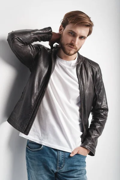 Fashion man, Handsome serious beauty male model portrait wear leather jacket, young guy over white background. — Stock Photo, Image