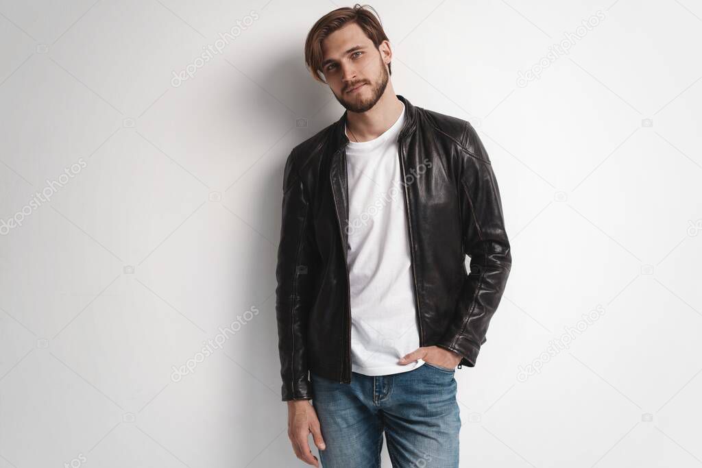 Fashion man, Handsome serious beauty male model portrait wear leather jacket, young guy over white background.