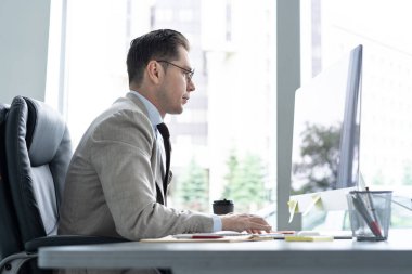 Ofiste çalışırken bilgisayar ekranına bakan genç bir çalışan..