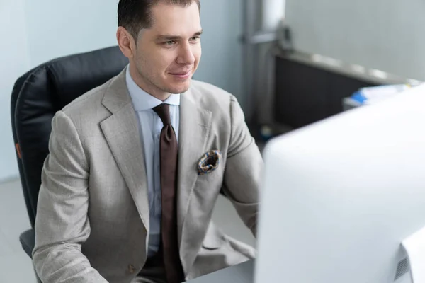 Young employee looking at computer monitor during working day in office. — Stock Photo, Image