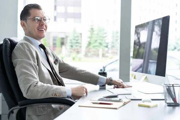 Νεαρός υπάλληλος που κοιτάζει οθόνη υπολογιστή κατά τη διάρκεια της εργάσιμης ημέρας στο γραφείο. — Φωτογραφία Αρχείου