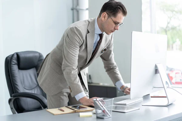 Young employee looking at computer monitor during working day in office. — Stock Photo, Image