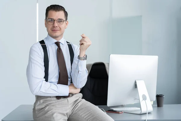 Portret van een zelfverzekerde jonge zakenman die alleen staat in een groot modern kantoor vlakbij zijn werkplek. — Stockfoto