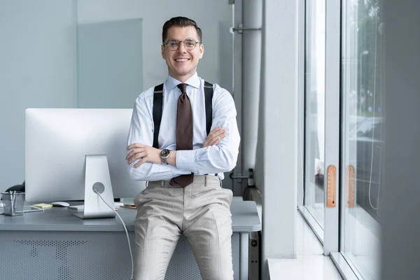 Portret van een zelfverzekerde jonge zakenman die alleen staat in een groot modern kantoor vlakbij zijn werkplek. — Stockfoto