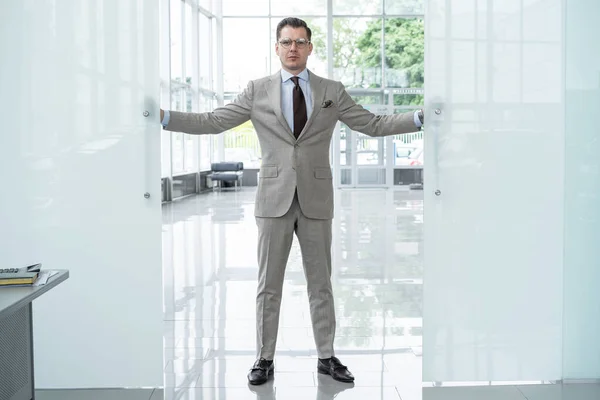 Bonito empresário confiante em terno entrando no escritório . — Fotografia de Stock