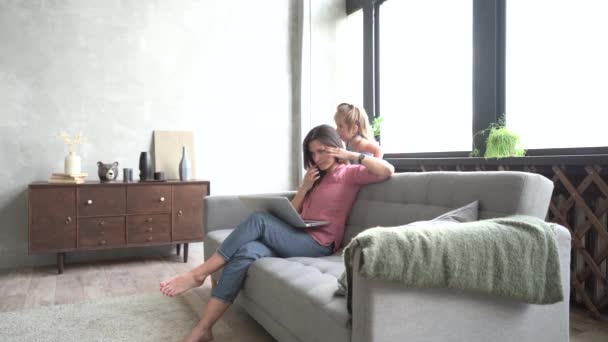 Madre trabajadora cansada. Empleos remotos y flexibles para mamá. Trabajo de padres estresados en el hogar. Ruidosa hija activa jugando en casa . — Vídeo de stock